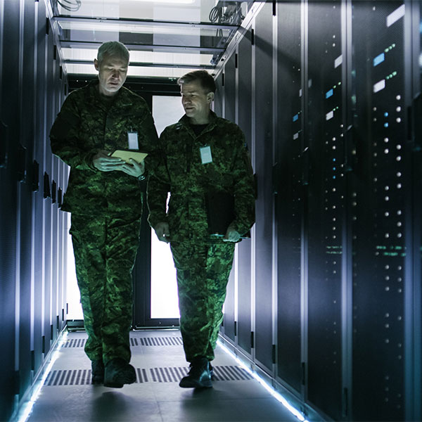Two miltary men walking through a server room